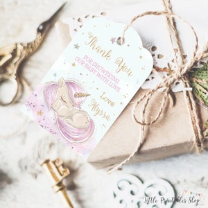 May include: A gift tag with a watercolor illustration of a sleeping unicorn with a gold horn and pink mane. The tag reads "Thank You For Showering Our Baby With Love, Love Alyssa" in gold script. The tag is tied to a wrapped gift.