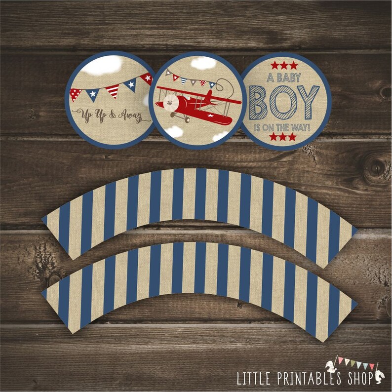 May include: Printable cupcake wrappers with blue and beige stripes. Three round cupcake toppers with a red airplane, blue and red bunting, and the text "A Baby Boy Is On The Way!"