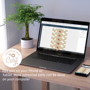May include: A laptop and smartphone display a design featuring a red airplane and white clouds on a tan background. The text "Edit text on your Phone or Tablet. More advanced edits can be done on your computer" is visible. A potted plant is on the left.