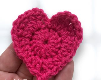 May include: A pink crocheted heart, a handmade craft project.