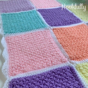 May include: A colourful crochet baby blanket with a white border. The blanket is made up of squares in different pastel colours, including pink, purple, blue, orange, and yellow. The text "Hookfully" is visible in the top right corner of the blanket.