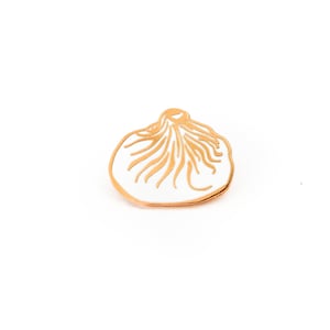 May include: A white enamel pin shaped like a dumpling with gold outlines.