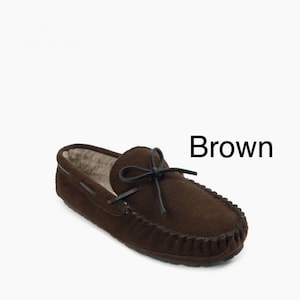 May include: Brown suede moccasin slippers with a black leather tie.