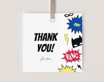 May include: White thank you tag with black text that says "THANK YOU!" and a signature that says "Hudson". The tag is decorated with colorful comic book style graphics including a black mask, yellow lightning bolts, red, yellow, and blue speech bubbles with the words "BANG", "ZAP!" and "POW!"