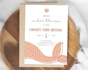 May include: A white invitation card with a pink mermaid tail illustration. The text reads "Come join us under the sea to celebrate Hannah's Third Birthday. Sunday June 15 2:00PM. The Smith Residence 123 Ocean Front Drive Tampa, IL RSVP to Meg at 555.555.5555"