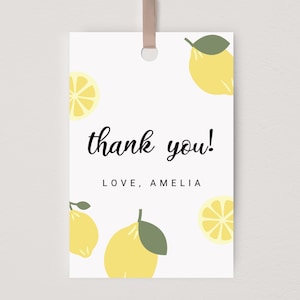 Könnte beinhalten: Eine weiße Dankeskarte mit Zitronen-Motiv. Die Karte zeigt den Text "thank you!" und "LOVE, AMELIA". Sie ist mit gelben Zitronen und grünen Blättern verziert.