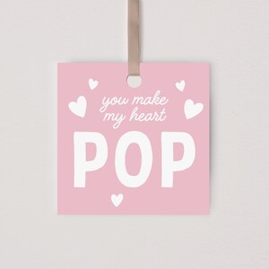 May include: Pink card with white hearts and the text "You make my heart POP" in white.