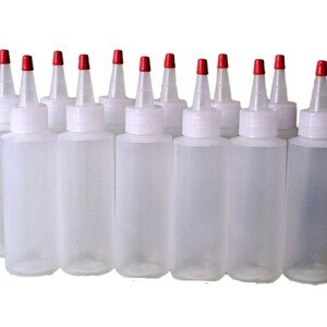May include: Ten clear plastic bottles with red squeeze tops. The bottles are empty and ready to be filled.
