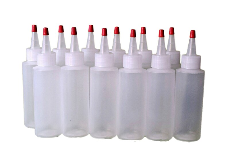 May include: Ten clear plastic bottles with red squeeze tops. The bottles are empty and ready to be filled.