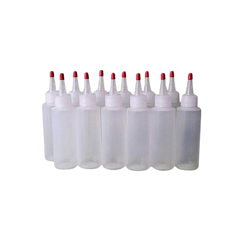 May include: A set of 12 clear plastic squeeze bottles with red caps. The bottles are all lined up in a row and are empty.