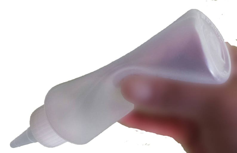 May include: A clear plastic squeeze bottle with a long, thin nozzle. The bottle is designed for dispensing liquids.