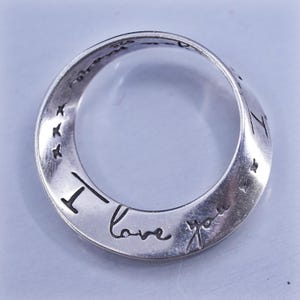 Könnte beinhalten: Silberner Ring mit der Gravur "I love you". Der Ring hat ein schlichtes, elegantes Design mit poliertem Finish. Er hat auch kleine Stern- und Vogelmotive.