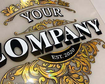 Pode incluir: Uma placa personalizada com o texto YOUR COMPANY em letras brancas em negrito com sombras pretas. O design é emoldurado por intrincados ornamentos de filigrana holográfica dourada e inclui uma faixa preta com o texto EST. 2020 em branco.