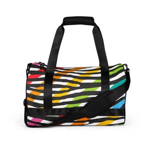Può includere: Borsa da viaggio nera e bianca con un vivace motivo a strisce zebrate arcobaleno. La borsa ha manici neri e una tracolla staccabile. Progettata per viaggi o palestra.