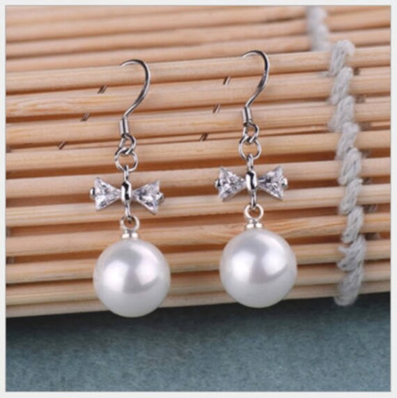 Lovely silver plated 10mm white seashell pearl bow rhinestone earrings