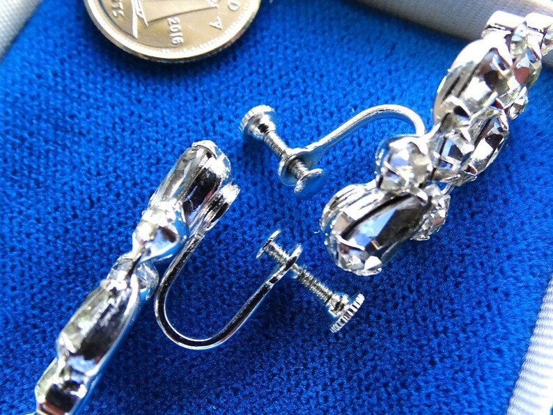 Prong set set sparkly marquise rhinestones set in rhodium plated metal. Clear stunning screw back vintage earrings