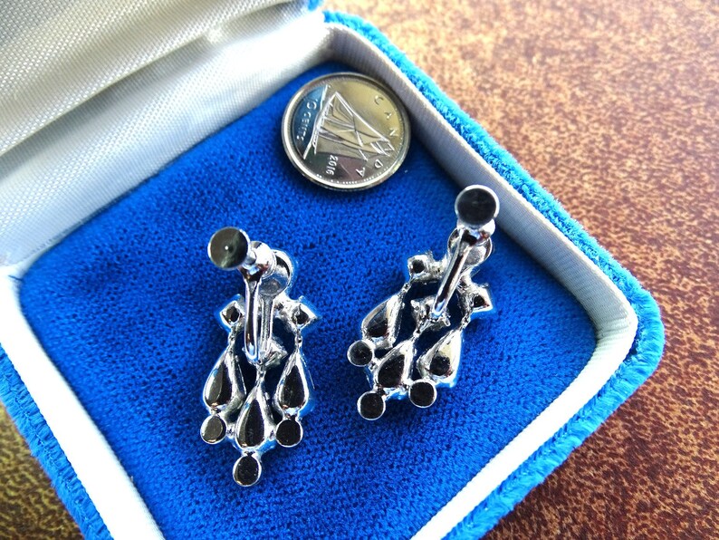 Prong set set sparkly marquise rhinestones set in rhodium plated metal. Clear stunning screw back vintage earrings