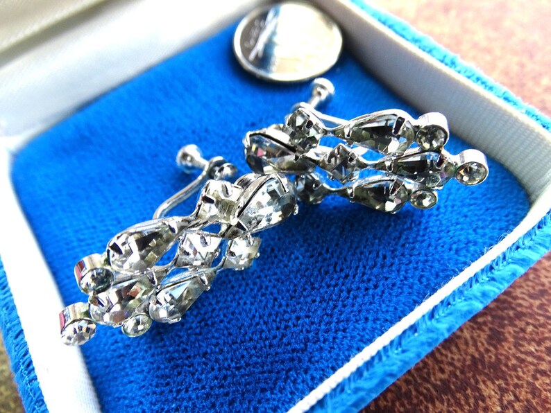 Prong set set sparkly marquise rhinestones set in rhodium plated metal. Clear stunning screw back vintage earrings