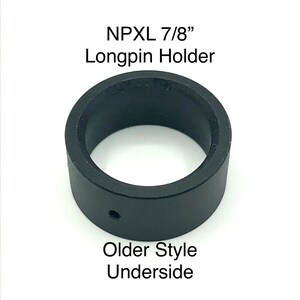 Puede incluir: Porta-longpin de pl&aacute;stico negro para un longpin de 7/8 de pulgada. El porta-longpin tiene un peque&ntilde;o agujero en la parte inferior. "NPXL 7/8" Longpin Holder" y "Older Style Underside" est&aacute;n impresos en la imagen.