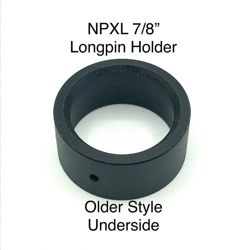 Puede incluir: Porta-longpin de pl&aacute;stico negro para un longpin de 7/8 de pulgada. El porta-longpin tiene un peque&ntilde;o agujero en la parte inferior. "NPXL 7/8" Longpin Holder" y "Older Style Underside" est&aacute;n impresos en la imagen.