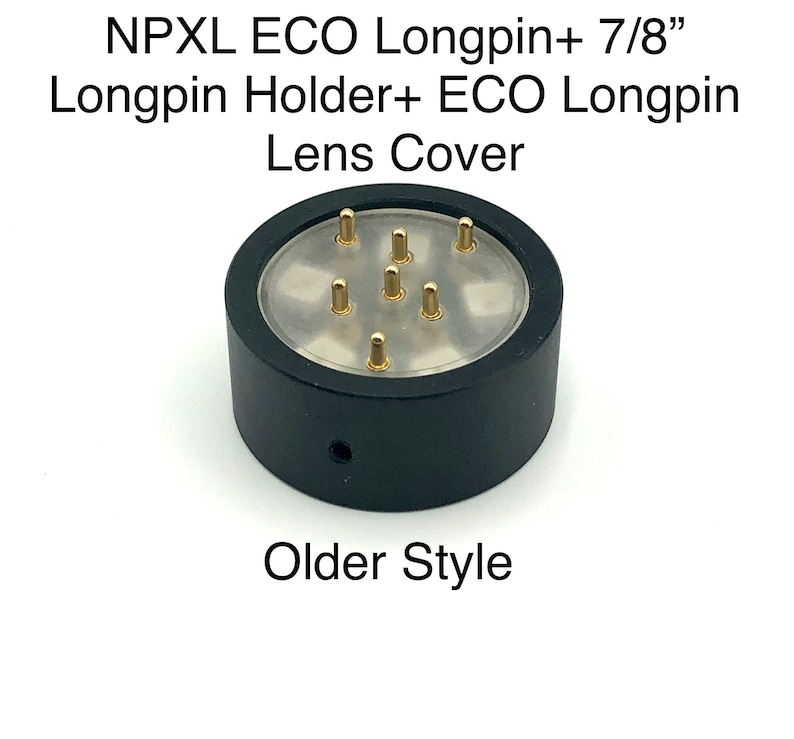 Puede incluir: Tapa de lente de pl&aacute;stico negro con parte superior transparente y pines de color dorado. El texto "NPXL ECO Longpin+ 7/8" Longpin Holder+ ECO Longpin Lens Cover" est&aacute; impreso sobre la tapa de la lente. El texto "Older Style" est&aacute; impreso debajo de la tapa de la lente.