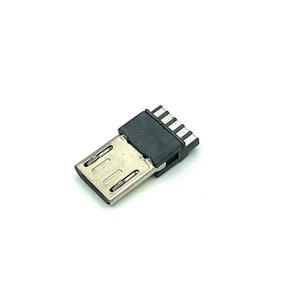 Puede incluir: Un conector micro USB negro y plateado con una pequeña carcasa de plástico negro. El conector tiene cinco pines en la parte superior y un conector metálico en la parte inferior.