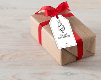 May include: A brown gift box with a red ribbon and a white gift tag. The gift tag has a black and white illustration of a Christmas tree with lights and a star on top. The text on the tag reads "NUR EINE KLEINE KLEINIGKEIT".