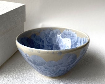 May include: A white ceramic bowl with a blue and white crackle glaze pattern.