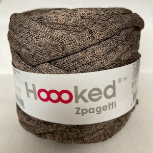 以下が含まれることがあります： 茶色とベージュのHooked Zpagettiの糸玉。ラベルには、ブランド名が赤と白で表示され、「Hooked」の文字と無限大のシンボルロゴが特徴です。クラフトプロジェクトに最適です。
