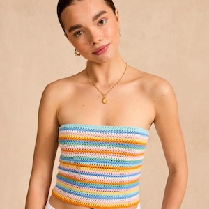 May include: A rainbow striped crochet tube top. The top is made of a soft, lightweight yarn and has a relaxed fit.