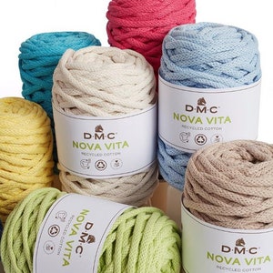 Könnte beinhalten: Eine Sammlung bunter Baumwollgarnknäuel, jedes mit einem weißen Etikett mit der Aufschrift "D-M-C NOVA VITA RECYCLED COTTON".