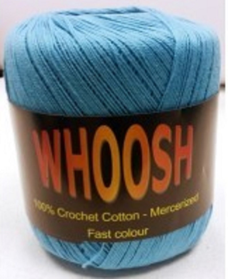 K&ouml;nnte beinhalten: Ein Kn&auml;uel hellblaues 100% H&auml;kelgarn aus Baumwolle mit dem Wort "WHOOSH" in orangefarbenen Buchstaben auf einem braunen Etikett. Das Etikett tr&auml;gt au&szlig;erdem die Aufschrift "Mercerisiert" und "Schnelle Farbe".