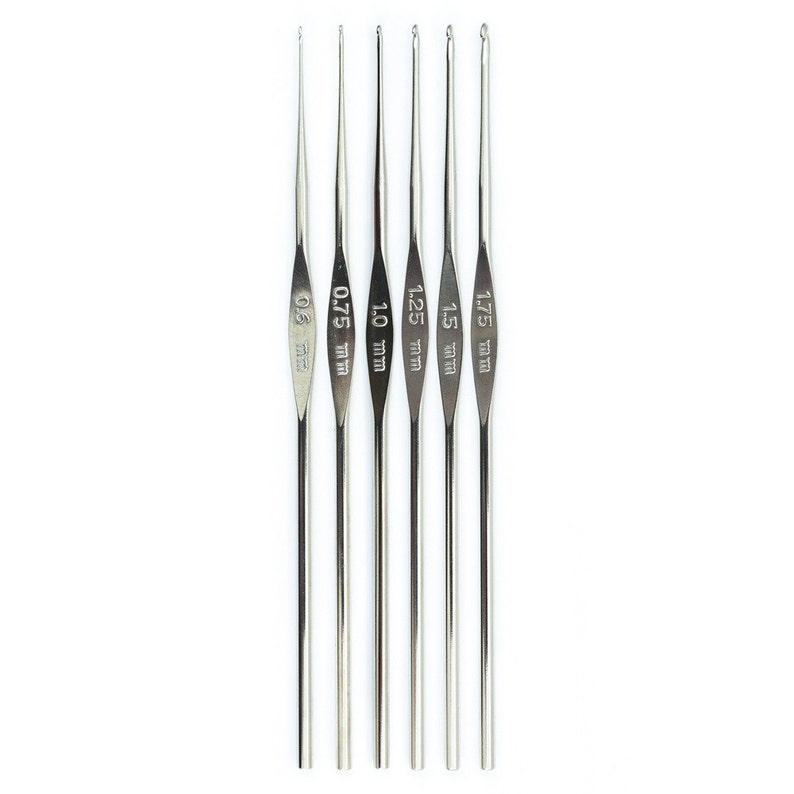 May include: Set of six silver crochet hooks with sizes 0.6 mm, 0.75 mm, 1.0 mm, 1.25 mm, 1.5 mm, and 1.75 mm.