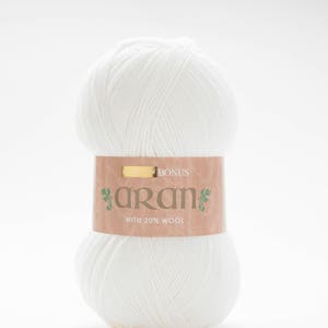 May include: A ball of white yarn with a brown label that says "Bonus Aran with 20% Wool".