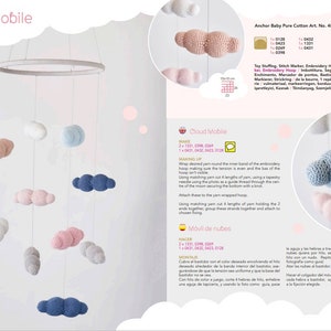 May include: A DIY crochet cloud mobile kit with instructions in English and Spanish. The kit includes yarn in pink, blue, and white to create six clouds that hang from a wooden hoop.