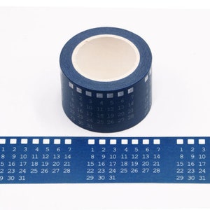 May include: A roll of blue washi tape with white numbers 1 through 31 printed on it. The tape is designed to look like a film strip.