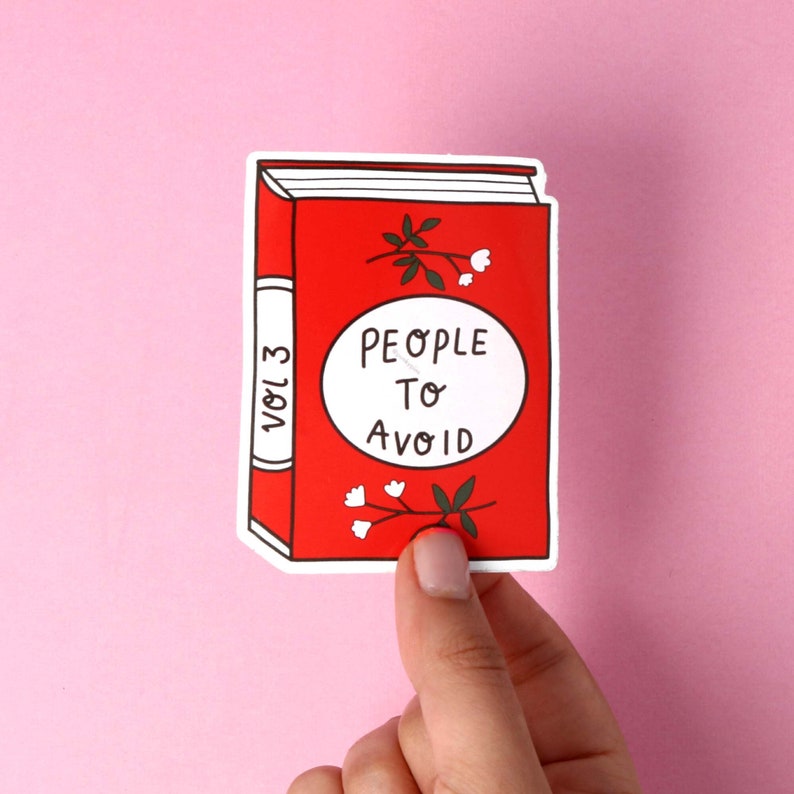 May include: A red book sticker with white text that reads "People to Avoid" and "Vol. 3" on the spine. The book has a white border and a simple illustration of a flower with white petals.