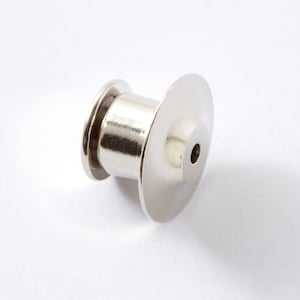 May include: A silver metal pin back with a round, flat top and a small hole in the center.