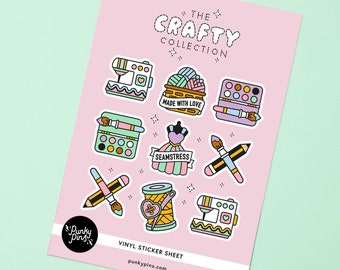 May include: A sheet of vinyl stickers featuring a variety of craft-themed designs. The stickers are pink, yellow, blue, and green. The designs include a sewing machine, a spool of thread, a paintbrush and pencil, a basket of yarn, a dress form, and a palette of paints. The text "The Crafty Collection" is at the top of the sheet. The text "Vinyl Sticker Sheet" and "punkypins.com" are at the bottom of the sheet.