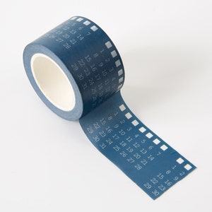 May include: A blue washi tape with a film strip design and numbers 1 through 31 printed on it.