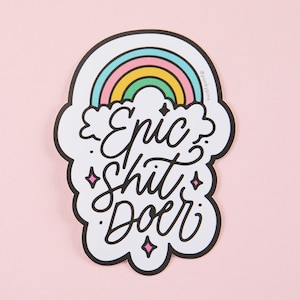 Op de afbeelding: Witte sticker met een regenboog, een wolk en de tekst "Epic Shit Doer".
