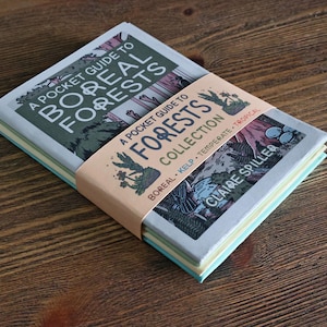 May include: A stack of three softcover books titled A Pocket Guide to Boreal Forests, held together by a peach-colored paper band labeled A Pocket Guide to Forests Collection by Claire Spiller, featuring illustrations of trees and plants.