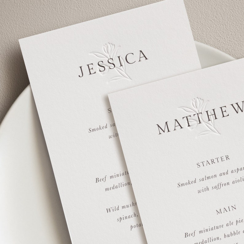 May include: Wedding menu cards with a floral design and the names Jessica and Matthew. The menu includes starter and main courses.