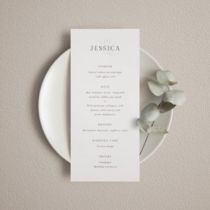 May include: A wedding menu card with a floral design and the name Jessica at the top. The menu includes starter, main, dessert, wedding cake, and drinks. The starter is smoked salmon and asparagus with saffron aioli. The main is beef miniature pie, chargrilled medallion, bubble and squeak, or wild mushroom wellington, with spinach, lattice pastry and potato dauphinoise. The dessert is passionfruit cheesecake, raspberry sorbet. The wedding cake is Victoria sponge. The drinks are champagne and sparkling fruit presse.