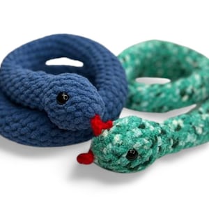 May include: Two crocheted snake toys, one blue and one green, with black eyes and red tongues.
