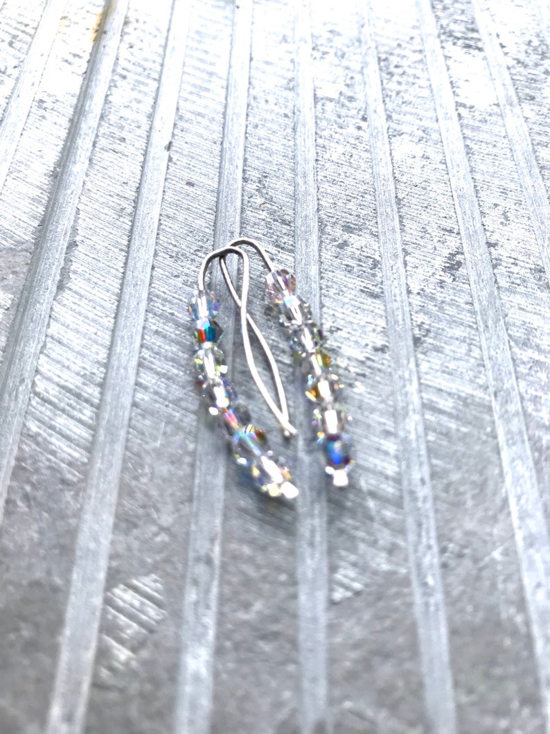 May include: A pair of silver earrings with clear crystal beads. The earrings are simple and elegant, and would be a great addition to any jewelry collection.