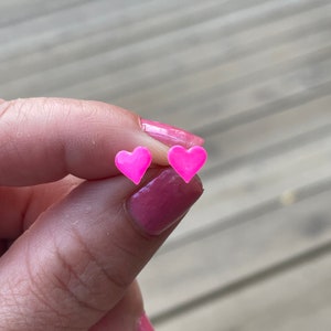 Puede incluir: Un par de pendientes de coraz&oacute;n rosa.
