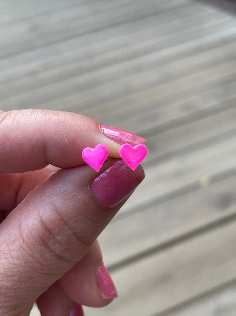 Puede incluir: Un par de pendientes de coraz&oacute;n rosa.