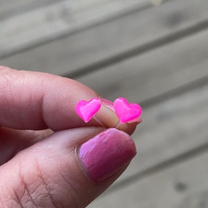 Puede incluir: Un par de pendientes de coraz&oacute;n rosa. Los pendientes son peque&ntilde;os y delicados, y son perfectos para a&ntilde;adir un toque de fantas&iacute;a a cualquier atuendo.