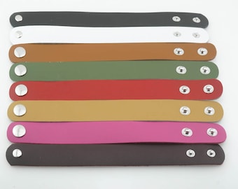 Può includere: Dieci braccialetti in pelle con chiusura in metallo argentato. I braccialetti sono di vari colori, tra cui nero, bianco, marrone, verde, rosso, giallo, rosa e marrone scuro.